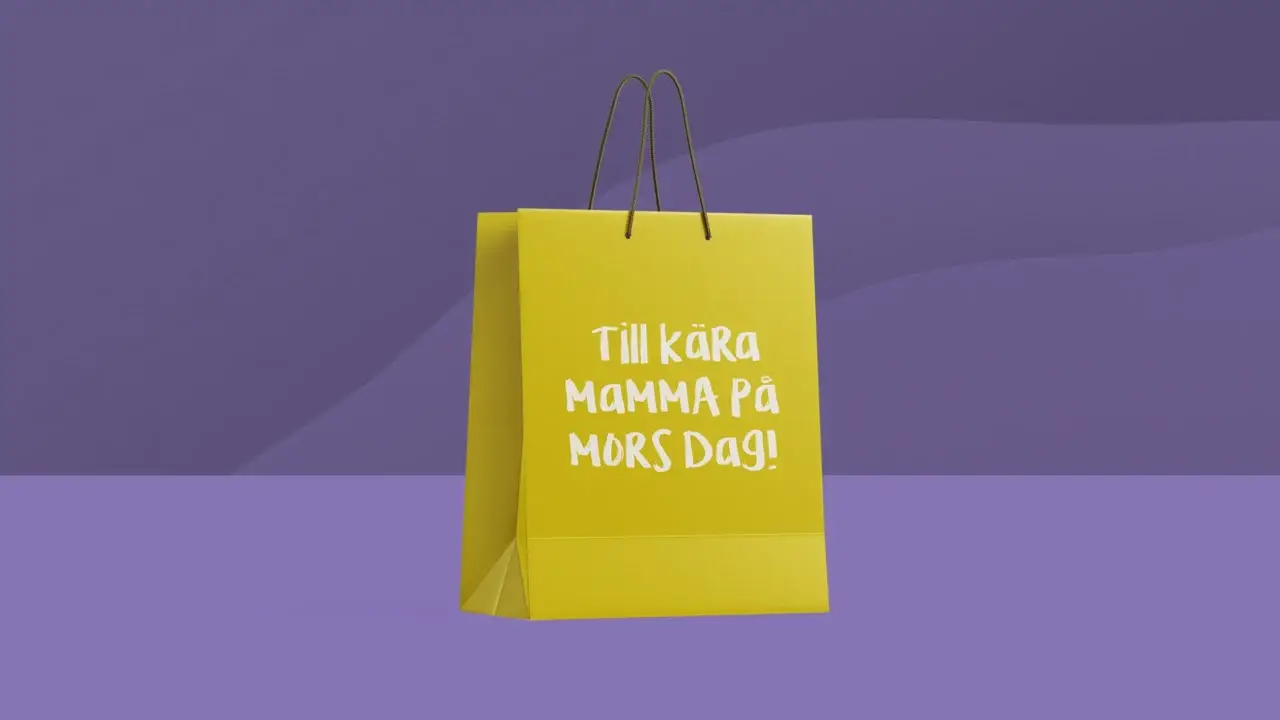 Gul shoppingväska med vit text som lyder "Till kära Mamma På Mors Dag!" (Till kära Mamma på Mors Dag!) mot en lila bakgrund.